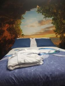 a bed with a towel on it with a painting at Moonlight in Vidigueira