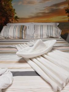 twee witte handdoeken bovenop een bed bij Moonlight in Vidigueira