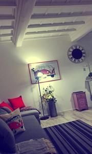 sala de estar con sofá y reloj en la pared en Le Logge del Banditore, en Anagni