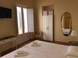 1 dormitorio con 1 cama grande y espejo en Life Apartments San Vicente, en Sevilla