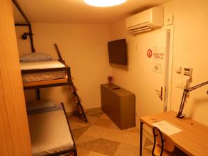 Zimmer mit Etagenbetten, einem Schreibtisch und einem Tisch in der Unterkunft Casa Riccobon in Koper