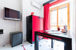 a room with a desk and a red refrigerator at Four Rooms in Carloforte