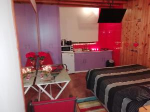 Habitación con mesa y cocina con iluminación roja. en Cabañas Mirador de Maitencillo, en Maitencillo
