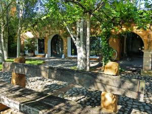 ławka przed budynkiem z drzewami w obiekcie Yeguada Senillosa - Turismo Rural w mieście Castelló d'Empúries