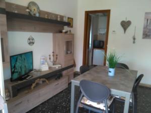 a living room with a table and a television at La Casa di Zoe - Terre del Magra in Bocca di Magra