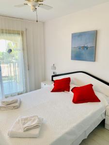 ミアミ・プラトーヤにあるApartamento vistas al mar, Playa Cristalのベッドルーム(白いベッド、赤い枕付)