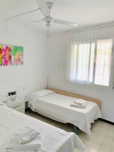 ミアミ・プラトーヤにあるHoming Miami Playa Cristal 10のベッド2台と天井ファン付きの寝室