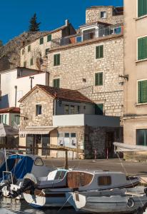 un bateau amarré dans une marina devant des bâtiments dans l'établissement Bounty Apartments, à Šibenik
