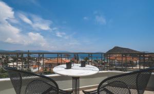 un tavolo e sedie su un balcone con vista sull'oceano di ELIXIA a Tolo
