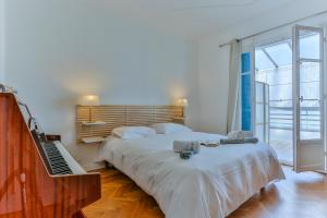 a bedroom with two beds and a piano and a keyboard at Maison Bianchi - 91 Promenade des Anglais in Nice