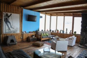 salon z drewnianą podłogą i niebieską ścianą w obiekcie Cordillera Hostel w mieście Farellones