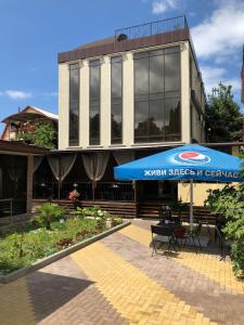 a blue umbrella sitting in front of a building at Guest House Panorama in Adler