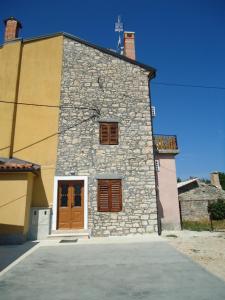 a stone building with a cross on the top of it at Apartments Ana in Savudrija