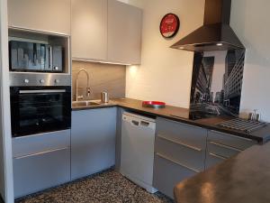 uma cozinha com armários brancos e um forno com placa de fogão em Les Cyclades em Le Lavandou