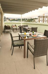 una mesa y sillas en un balcón con una comida en Suites las Palmas, Hotel & Apartments., en San Salvador