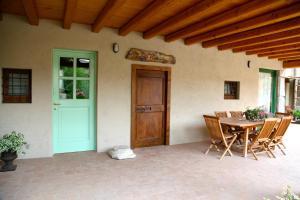 a patio with a wooden door and a table and chairs at A Casa Di Mìnola in Roe