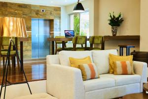 uma sala de estar com um sofá branco e uma mesa em Suites las Palmas, Hotel & Apartments. em San Salvador