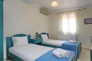 1 dormitorio con 2 camas y toallas. en ANTONIOS Skopelos studios apartments, en Skopelos Town