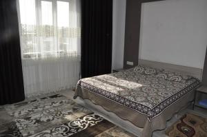 a bedroom with a bed and a window at Guest House Nur in Kochkorka