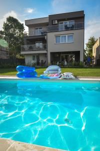 a swimming pool in front of a house at Francesca Apartman in Siófok