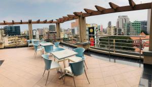 balkon ze stołami i krzesłami oraz widokiem na miasto w obiekcie Golden Park Hotel w mieście Luanda