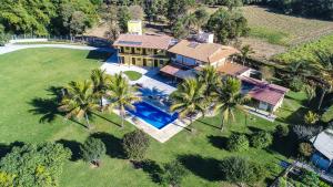 an aerial view of a house with a pool and palm trees at Pousada Cateto - Zona Rural in Capitólio