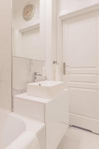 La salle de bains blanche est pourvue d'un lavabo et d'un miroir. dans l'établissement Luxury in Old Town - free parking, à Gdańsk
