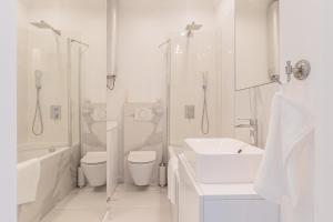 La salle de bains blanche est pourvue d'un lavabo, de toilettes et d'une douche. dans l'établissement Luxury in Old Town - free parking, à Gdańsk
