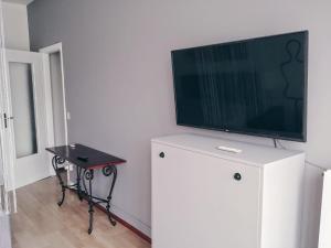 a flat screen tv sitting on top of a white cabinet at Appartamento con terrazzo zona ospedale civile in Brescia