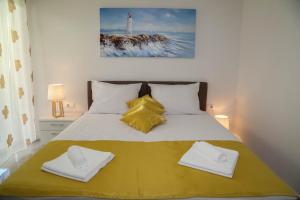 a bedroom with a large bed with yellow and white pillows at Apartments Paradise Hvar in Hvar