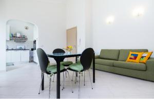 sala de estar con mesa, sillas y sofá en Casa Veronica, en SantʼAntìoco