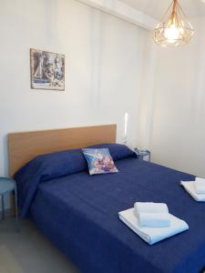 a bedroom with a blue bed with towels on it at Casa Vacanze Vicè in Castellammare del Golfo