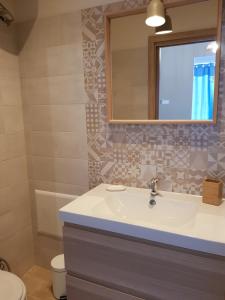 a bathroom with a sink and a mirror and a toilet at Casa Vacanze Vicè in Castellammare del Golfo
