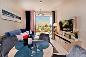 una sala de estar con una mesa con copas de vino en BlueApart Apartamenty Na Plaży Jastarnia en Jastarnia