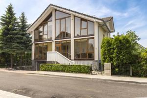a house with large windows on the side of a street at SAULES SVECIU NAMAI in Palanga