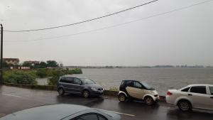 three cars parked in a parking lot next to a body of water at Apartament Lenus'k in Bucharest