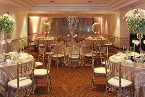 a banquet hall with tables and chairs and flowers at Clarion Suites Guatemala City in Guatemala