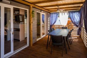 a dining room with a table and chairs on a deck at Mobile Home HappyNest in Biograd na Moru