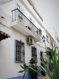 マルベーリャにあるCasa-Casitaの青い窓とバルコニーが備わる白い建物