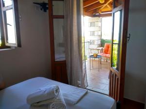 - une chambre avec un lit et une vue sur une terrasse dans l'établissement Atha-Tina:Traditional Stone Homes, à Agios Nikolaos