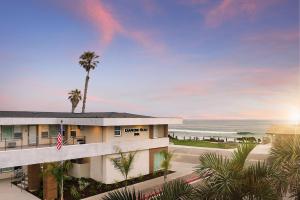 um edifício com uma palmeira em frente ao oceano em Diamond Head Inn em San Diego
