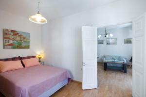 ein Schlafzimmer mit einem Bett und ein Wohnzimmer in der Unterkunft Andrew's Old Town Apartment by CorfuEscapes in Korfu-Stadt