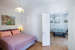 a bedroom with a bed and a living room at Andrew's Old Town Apartment in Corfu