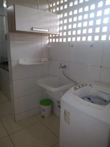 ein weißes Bad mit einem WC und einem Waschbecken in der Unterkunft Castanheiras 3 Quartos in Guarapari