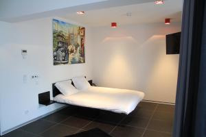 Schlafzimmer mit einem Bett mit Wandgemälde in der Unterkunft Hotel Grey in Luxemburg (Stadt)