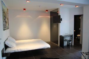 una camera da letto con un letto, una scrivania e una televisione di Hotel Grey a Lussemburgo