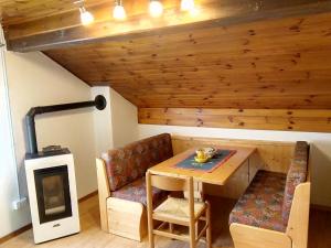 a room with a table and a chair and a stove at B&B PRA' DEI CERVI in Telve