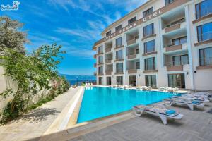 a hotel with a swimming pool and lounge chairs at Erpey Ferah Apart Otel in Balıkesir