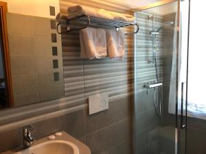 a bathroom with a sink and a glass shower at Hotel Kalemi in Gjirokastër