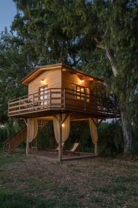 a tree house on a stand in the grass at River TreeHouse in Laganas